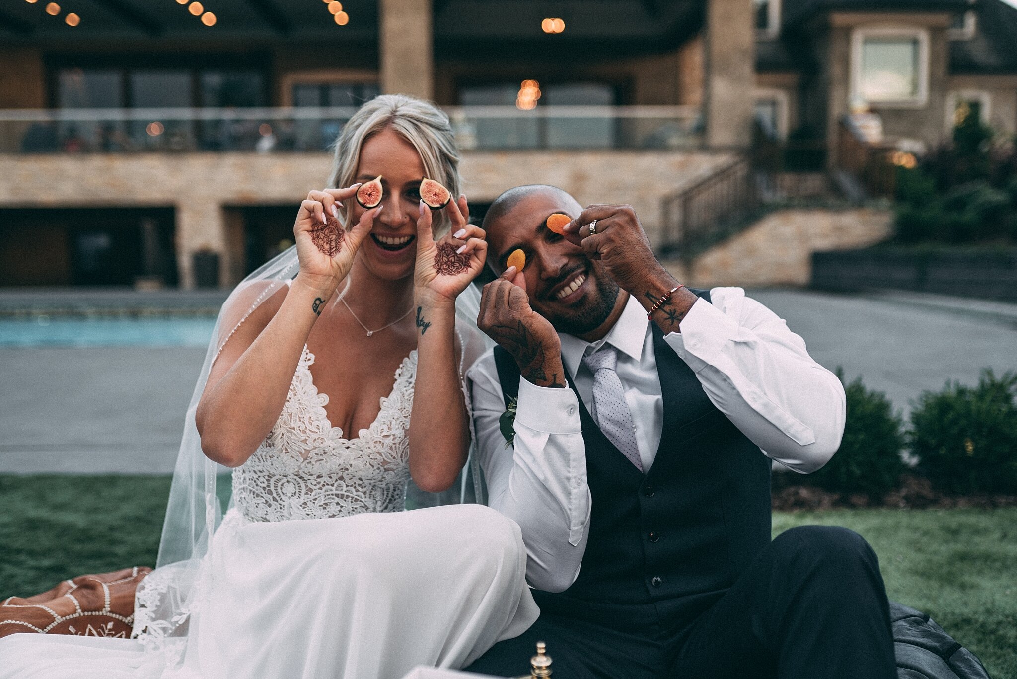 bride and groom eating charcuterie board and pretending fruit are their eyes