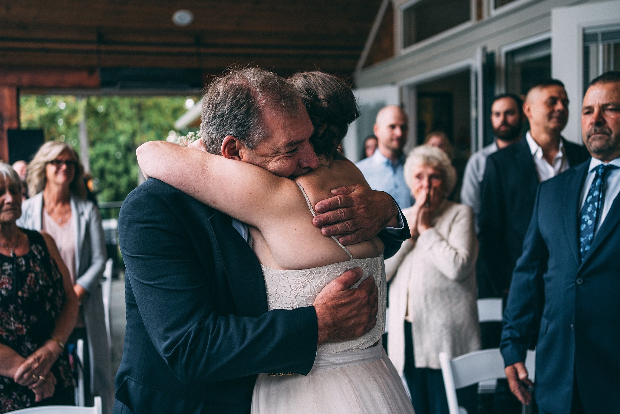 bride hugging her dad top at wedding alter