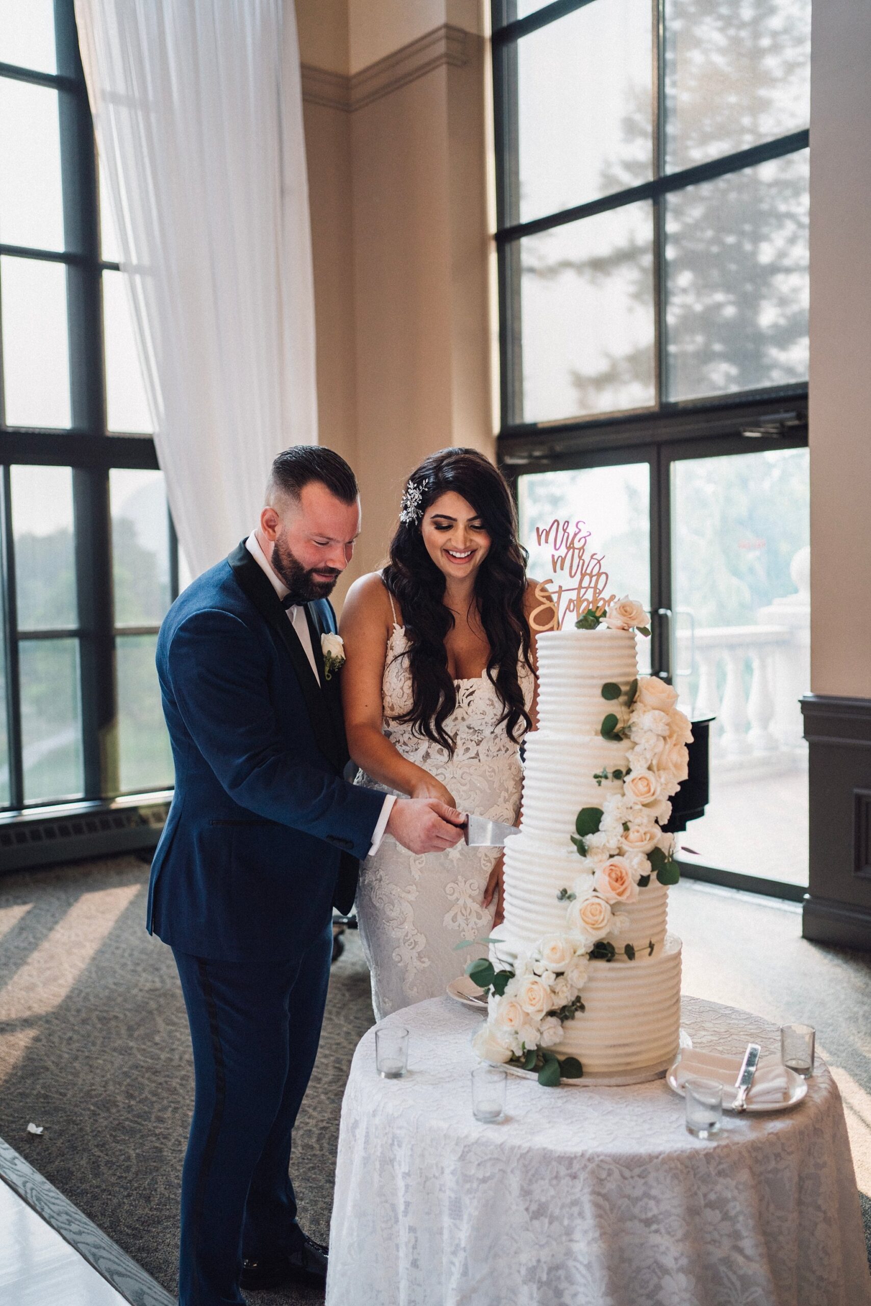 bride and groom cutting a 4 tier white wedding cake