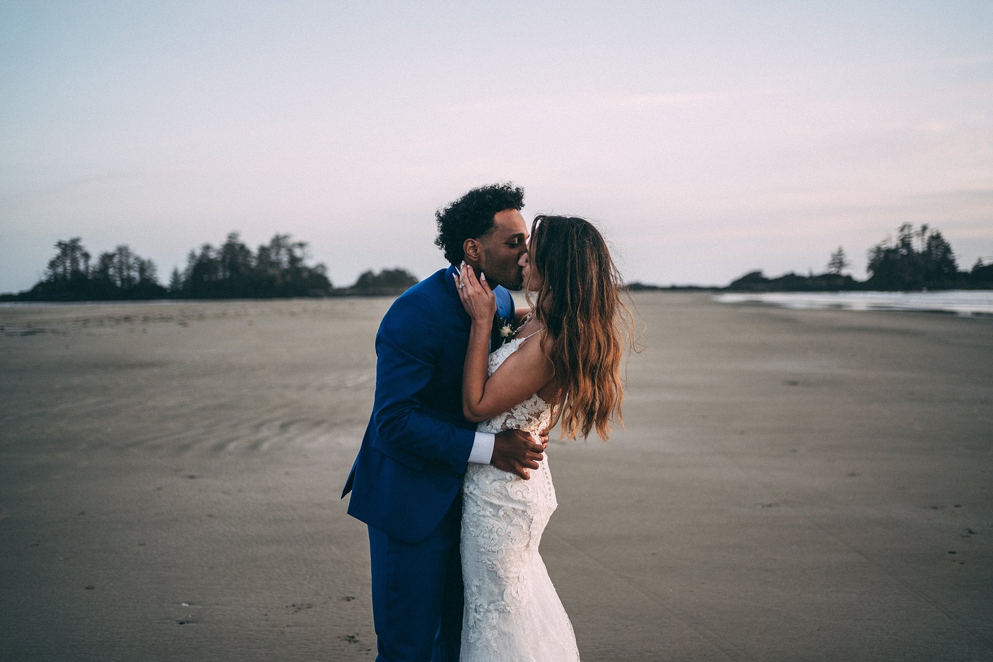 bride and groom kissing at beach
