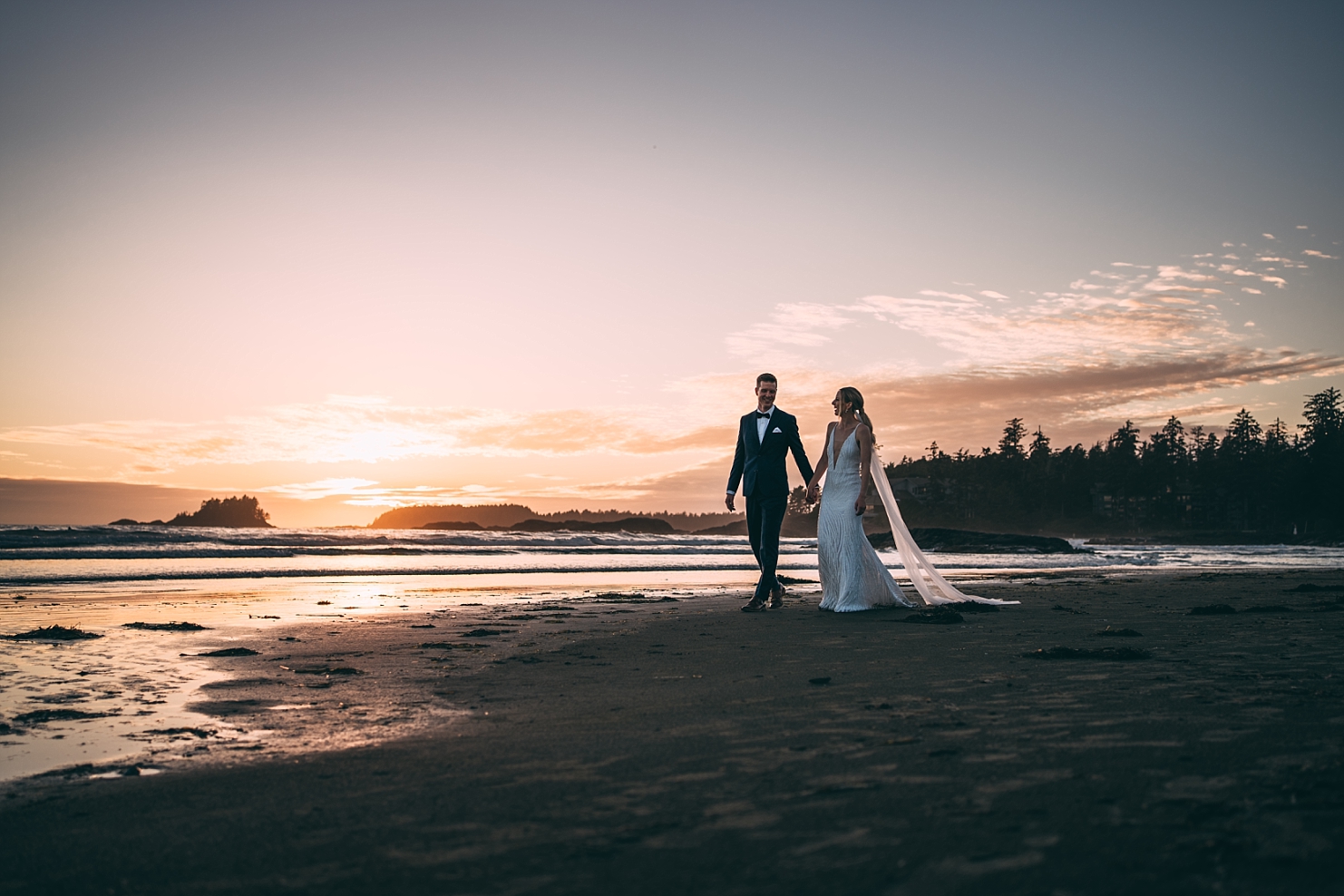 wedding couple walking on chesterman beach at sunset