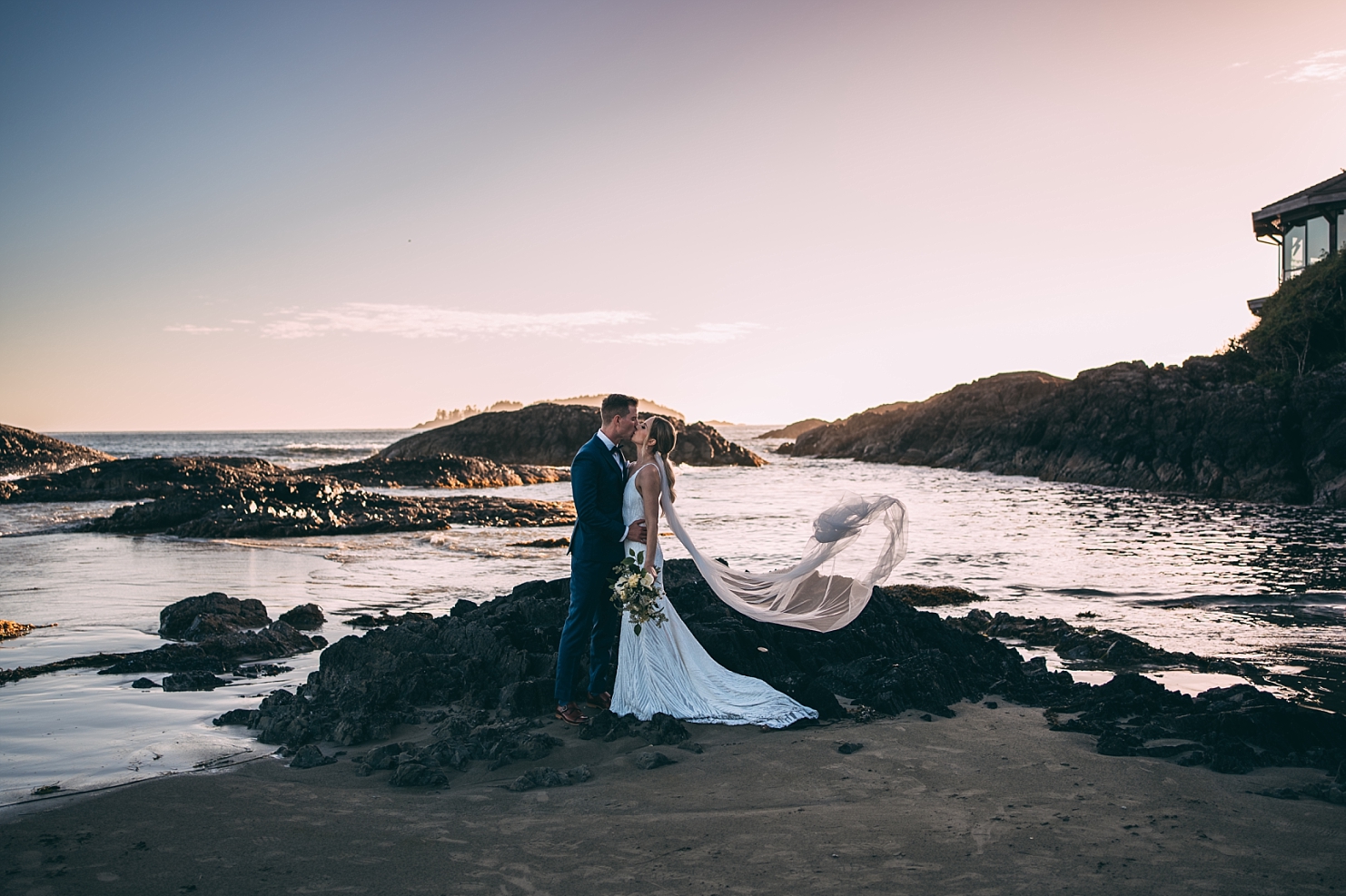 bride and groom kissing at chesterman beach in front of ocean at sunset